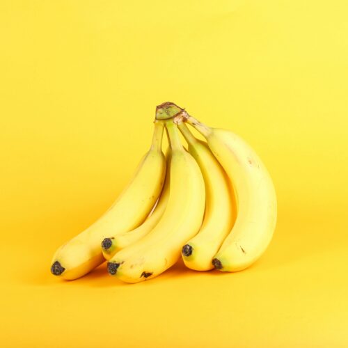 A bunch of bananas on a yellow background.