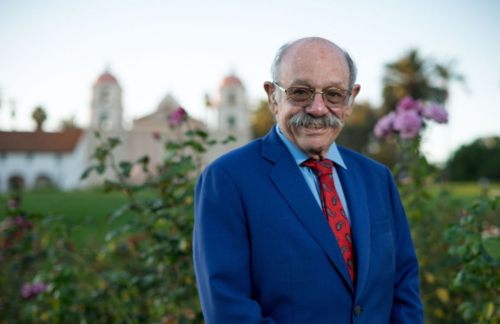 Dr. David Bearman wears a blue suit and red tie and stands in front of Mission Santa Barbara in Santa Barbara, California. Dr. Bearman's Endocannabinolgy course prepares clinicians for cannabis resceduling